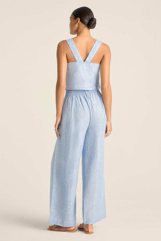 Woman turned away wearing a blue and white striped beach tank top with matching pants