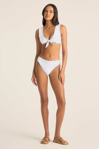Woman wearing a white swim top and white swim bottoms