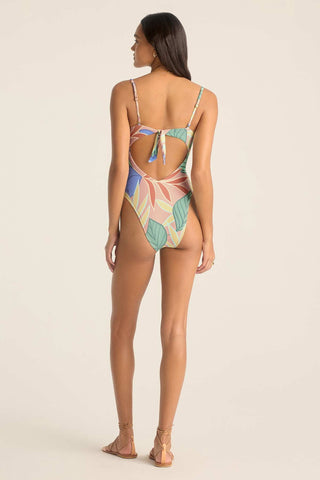 Woman turned away wearing a bandeau one-piece jungle printed swimsuit with straps